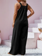 Rear view of black Harmonique overalls with clean seam detail and wide straps.