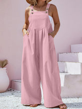 Side shot of model in dusty pink overalls paired with platform sneakers for a casual brunch look.