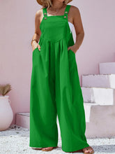 Model wearing green Harmonique Wide-Leg Overalls, paired with a white blouse and sneakers, perfect for a casual day out.