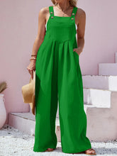 Close-up of green Harmonique overalls' square neckline and center pocket detail.