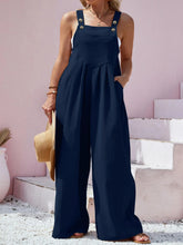 Side angle of navy Harmonique overalls paired with canvas sneakers.