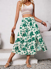 Full body view styled with white spaghetti crop top and white strappy heels paired with Havélyra Bloom Skirt Mid Green 
