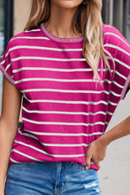 Model wearing striped knit round neck short sleeve top, front view in hot pink and white stripes, paired with denim jeans.