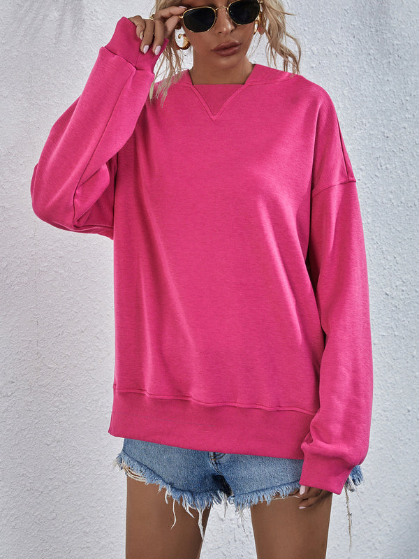 Model wearing hot pink Zephyra Breeze Dropped Shoulder Hoodie paired with tinted glasses, jewelry, and light blue denim shorts.