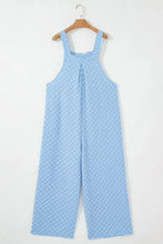 Back view of light blue checkered overalls with v-neck and straps on hanger.