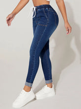 A woman posing from the side wearing the Kavoya DriftFlex Elastic Waistband & Drawstring Cropped Denim Pants paired with a  white blouse and white sneakers.