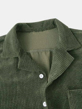Close-up of Army Green Kavren TextureFlex Duo top highlighting notched collar, textured fabric, and white button detail