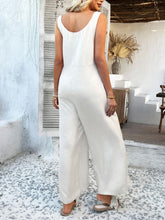 Back view of beige jumpsuit with scoop neckline and knotted straps.