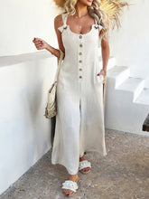 Beige jumpsuit paired with a woven clutch for a daytime chic ensemble.