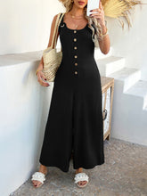 Black jumpsuit paired with an evening clutch for a refined look.