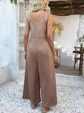 Back view of taupe jumpsuit with a graceful scoop neckline.