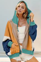 Front view of model in a khaki Full Size Color Block Zip Up Hoodie, displaying the understated neutral tones paired with contrasting panels, front zipper closure, and laid-back fit.