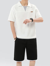 Man in white Johnny collar set glancing at wristwatch, showcasing casual sophistication.
