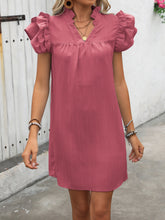 Model wearing the dusty pink ruffled notched cap sleeve dress.