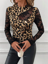 Model enjoying a city rooftop brunch wearing the Lace Patchwork Mock Neck Top in leopard, styled with wide-leg trousers, heels, and gold accessories.