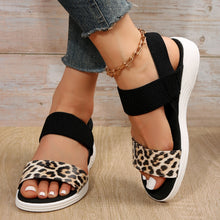 Model wearing Leopard PU Leather Open Toe Low Heel Sandals with legs crossed 