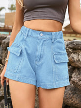 Woman in a bright yellow crop top and light blue Joyful Journey Denim shorts enjoying ice cream on a sunny day.