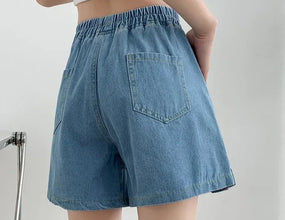 Back view of plus size light blue ruffle hem jean shorts with pockets.