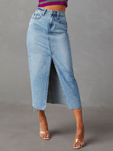 Light blue Denvara Wasked Denim Midi Skirt styled with contrast stripe crop top and clear heels for a casual look