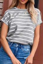 Woman wearing light gray striped knit short sleeve top at a weekend pool party, styled with shorts, and sneakers.