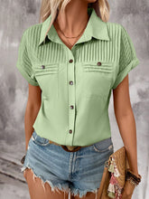 Side profile of model in a light green pleated collared neck blouse with cuffed sleeves, styled with gold hoop earrings and neutral sandals.