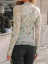Back view of model in light green mock neck long sleeve top showing clean lines and fitted silhouette.