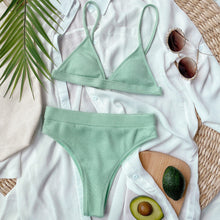 Front flat lay of light green spaghetti strap ribbed bikini set displayed on hanger with adjustable straps