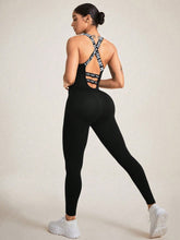 Angled close-up showing strappy back detail and weave of black LuminaCross Apex Jumpsuit.
