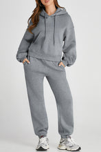 Model wearing gray Lunetta DriftSet, front view showcasing hooded top and relaxed-fit pants.