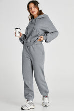 Model walking outdoors in gray Lunetta DriftSet, hands in pockets, casual stroll.