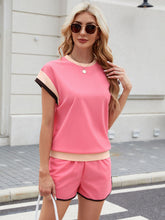 Model seated in coral Lustressa™ Shorts Set sipping coffee at café.
