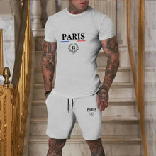 Front view image of model wearing a gray Luvéris Paris Crest Set standing in front of an elegant staircase.