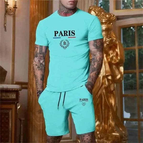 Man in turquoise Luvéris Paris Crest Set with hands in pockets at in an elegant interior setting.