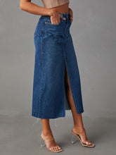 Side view of medium blue Denvara Raw Hem Front Slit Denim Midi Skirt highlighting pockets and belt loops detail