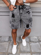 Model wearing men's embroidered distressed dark gray denim shorts front pose.