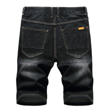 Back view showing rear pockets and slim fit of men's black denim shorts.