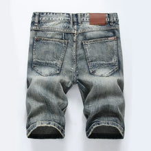 Back view showing rear pockets and slim fit of men's grey denim shorts.
