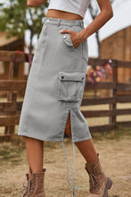 Mid gray Rovelle Cargo Skirt side view showing button pocket detail with white top and boots