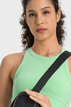 Close-up of green Aero Racerback Tank paired with a cross-body bag
