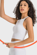 Woman in white Aero Racerback Tank performing yoga stretch