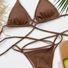 Close-up flat lay of mocha halter neck crisscross ribbed bikini set highlighting ribbed fabric texture and long adjustable straps