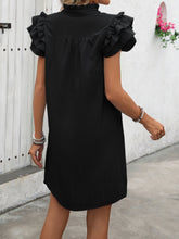 Model showcasing a back view of a Calivémuse™ black Ruffled Dress paired with jewelry. 