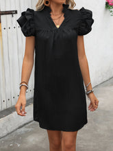 Model zoomed-in view wearing the black ruffled notched mini dress.