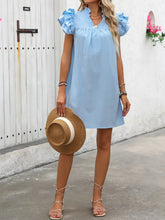 Model posing with a straw hat wearing the Pastel Blue ruffled notched cap sleeve mini dress.