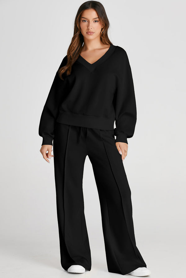 Model in Black MotoLux Vesper set, front angle styled with gold hoop earrings and sneakers.