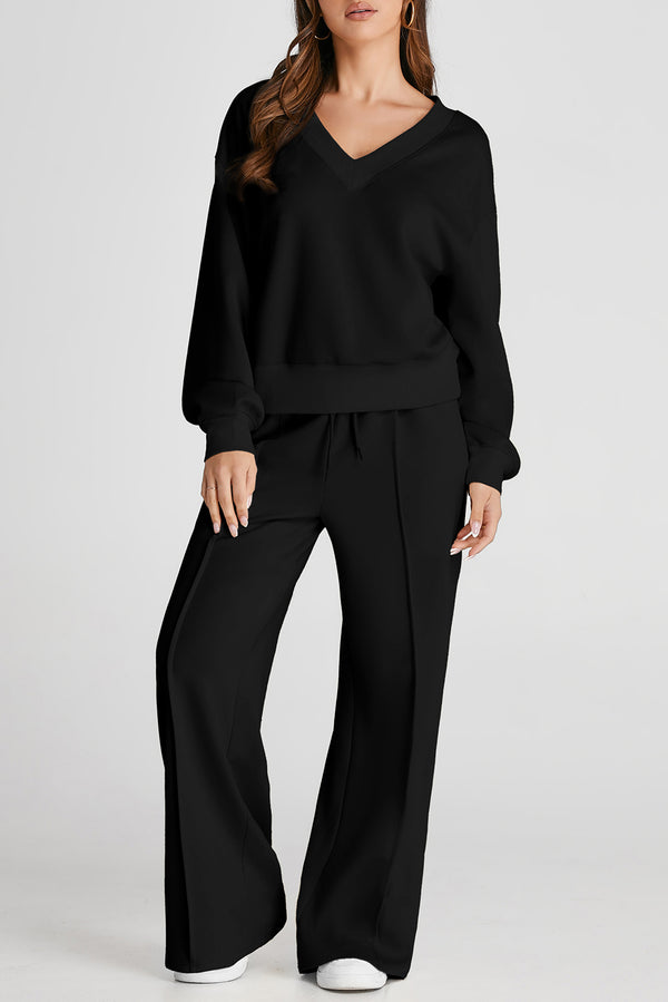 Model in Black MotoLux VesperActive set, front view showcasing v-neck top and fitted pants.