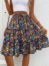 Side view of multi turquoise Florévyn Floral Print Midi Skirt with decorative waist tie, frill tiers, and ruffled hem