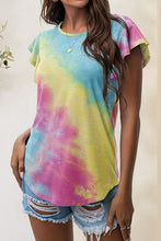 Model pairing multicolor printed flutter sleeve t-shirt with distressed denim