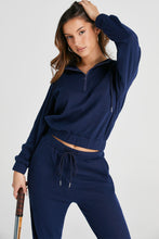 close-up front pose angle of navy Navaro Duo hoodie and joggers with tennis racket