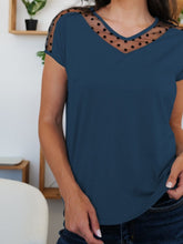 Close-up of a navy short sleeve V-neck T-shirt, highlighting the sheer polka dot mesh at neckline and shoulder panels.